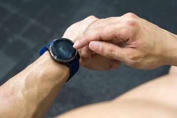 Close-up of athlete wrist with a sleek, modern smartwatch. Metallic, with a touch screen display.