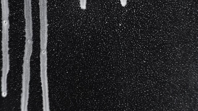 Soap foam water running down a glass. 