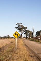 Rural Dirt Road With Left Hand Arrow Warning Sign