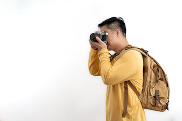 Smiling Asian photographer carrying a backpack taking pictures with a camera Isolated studio, white background.