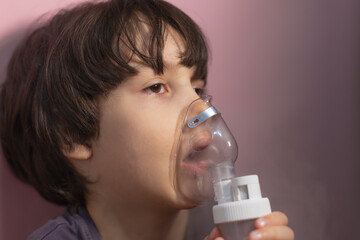 the child does inhalation, the boy inhales the medicine through the mask