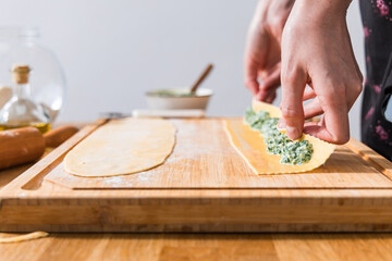 Preparing ravioli with ricotta cheese and spinach. Fresh homemade pasta. Traditional Italian food.