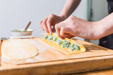 Preparing ravioli with ricotta cheese and spinach. Fresh homemade pasta. Traditional Italian food.