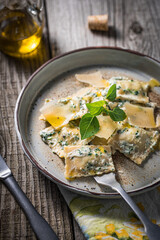 Ravioli with ricotta cheese, parmesan and spinach. Garnished with basil leaves and olive oil. Fresh and tasty classic Italian pasta dish.