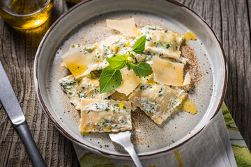 Ravioli with ricotta cheese, parmesan and spinach. Garnished with basil leaves and olive oil. Fresh and tasty classic Italian pasta dish.