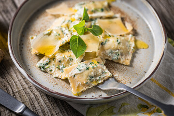 Ravioli with ricotta cheese, parmesan and spinach. Garnished with basil leaves and olive oil. Fresh and tasty classic Italian pasta dish.