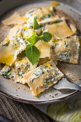 Ravioli with ricotta cheese, parmesan and spinach. Garnished with basil leaves and olive oil. Fresh and tasty classic Italian pasta dish.
