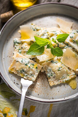 Ravioli with ricotta cheese, parmesan and spinach. Garnished with basil leaves and olive oil. Fresh and tasty classic Italian pasta dish.