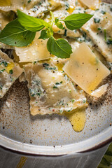 Ravioli with ricotta cheese, parmesan and spinach. Garnished with basil leaves and olive oil. Fresh and tasty classic Italian pasta dish.
