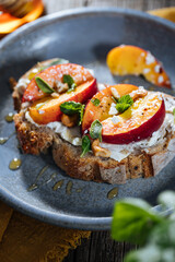 Spread with cream cheese on bread with rucola, nuts and peach. Healthy summer brunch. Vitamins and minerals