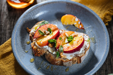 Spread with cream cheese on bread with rucola, nuts and peach. Healthy summer brunch. Vitamins and minerals