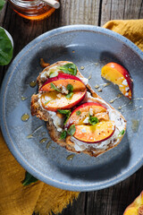 Spread with cream cheese on bread with rucola, nuts and peach. Healthy summer brunch. Vitamins and minerals