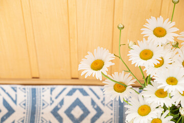 Obraz premium SSummer bouquet of delicate daisies on the background of a wooden wall wall. Postcard for Mother's Day or March 8. Idea for a postcard, congratulations. copy space