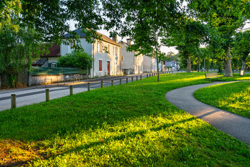 Public park at sunset with large trees in the French town of Morlaas,