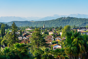 Fototapeta na wymiar Houses of the city of Pau among the trees and facing the Pyrenees on a sunny day, France.