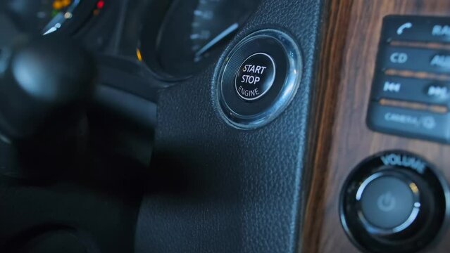 Short video finger pressing a button to start a car engine, side view, close up. Finger confidently engages the button, initiating the car's ignition process. Automotive technology, convenience, easy 