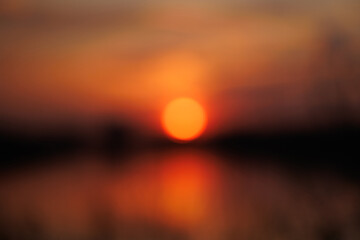 Blurred bokeh of a bright sunset on the beach and water reflection. High quality photo