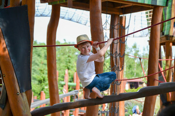 Obraz premium life of children in a modern city - little boy is having fun on the playground near the house