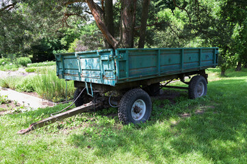 Old green trailer on the field.