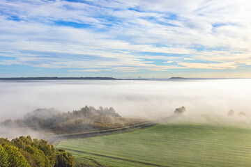 Cultivated landscape with fog in a valley