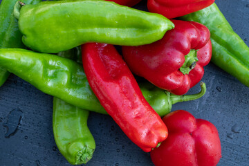 red and green organic peppers on black table