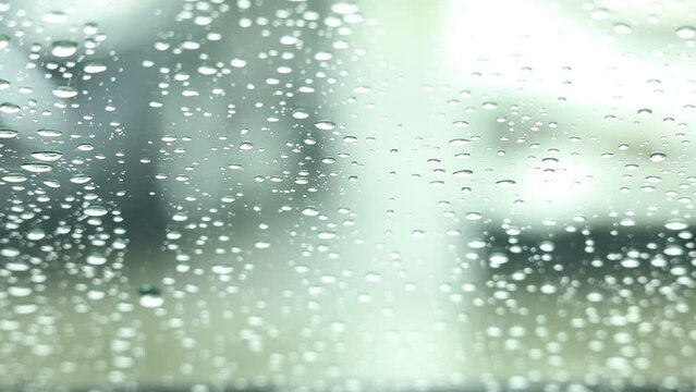 車の窓ガラスに降る雨の水滴