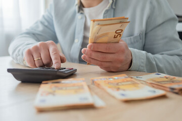 business, finances, accounting and people concept - man with money and calculator filling papers at home. savings, economy and home 