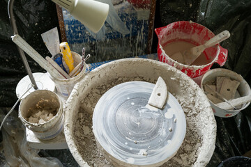 A ceramic artist's workstation.  Clay splashes and tools.