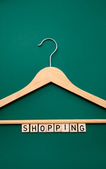 Clothes hanger, Wooden hanger on a green background in a minimalist style. with the inscription...