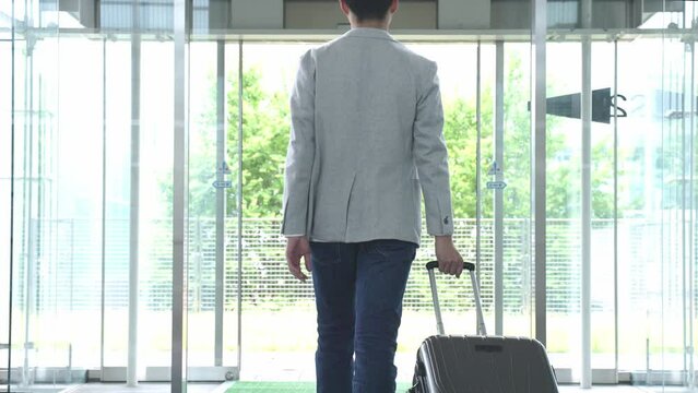 スーツケースをひき歩く男性