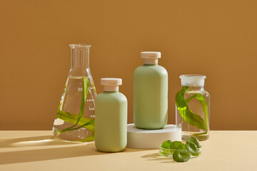 Cosmetic bottles in pastel color arranged with transparent jar and conical flask filled with seaweed and water. The benefits of seaweed for skin include humectant properties