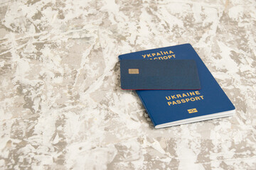 Passport of a citizen of Ukraine and a modern credit bank card with a chip on a light table. The...