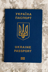 Foreign passport of a citizen of Ukraine on gray background. Concept of the departure of Ukrainians abroad or the stay of Ukrainian citizens outside the state in connection with the war with Russia.