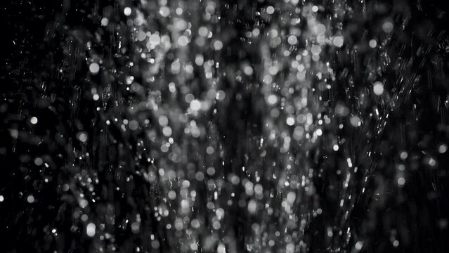 Shower rain bokeh from below with a black background