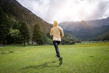 Woman trail runner cross country running in beautiful grassland