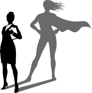 A superhero business woman revealed by her shadow silhouette as a super hero in a cape