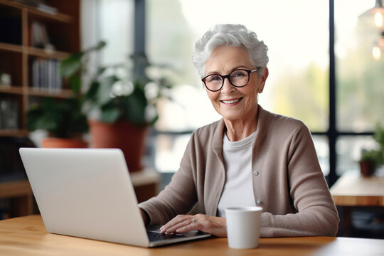 Smiling senior woman with laptop working at home office. AI