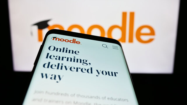Stuttgart, Germany - 07-08-2023: Smartphone with website of learning platform Moodle on screen in front of logo. Focus on top-left of phone display.