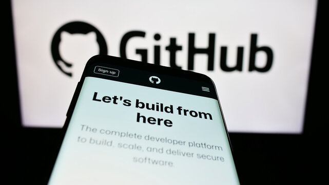Stuttgart, Germany - 07-09-2023: Mobile phone with webpage of US software development company GitHub Inc. on screen in front of business logo. Focus on top-left of phone display.