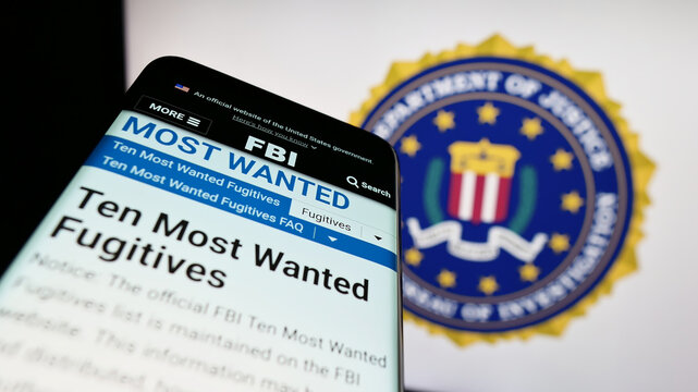 Stuttgart, Germany - 07-09-2023: Smartphone with website of US Federal Bureau of Investigation (FBI) on screen in front of seal. Focus on top-left of phone display.