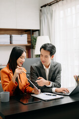 Two Asian businesswoman discuss investment project working and planning strategy with tablet laptop computer in  office.