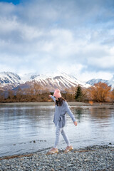 Asian female model enjoy the beautiful scenic sunrise view of Lake Pukaki east bank, with their mesmerizing turquoise hue and reflect the majestic snow-capped Southern Alps.