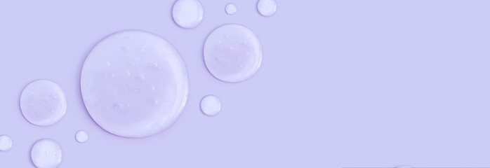 round drops of transparent gel serum on a pastel background