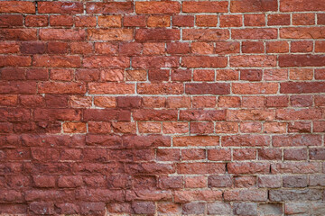 Texture of an old damaged brown brick wall as an architectural background