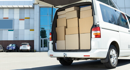 A white delivery service car with boxes inside