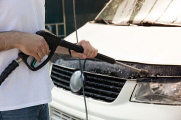 A man washes a car at a self-service car wash