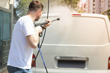 A man washes a car at a self-service car wash