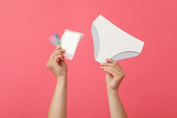 Menstrual panties in hands, on a pink background