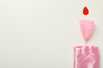 Menstrual cup with a red drop on a white background