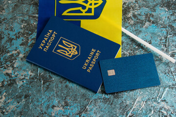 Flatlay on a dark background, Ukrainian passport, flag and bank card